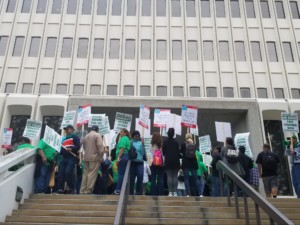 People on strike outside of Aldrich Hall, carrying signs